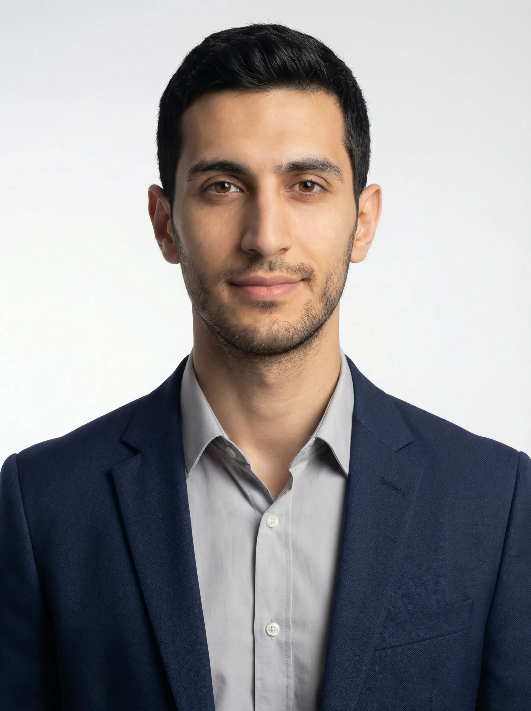 Operations team headshot in a navy suit on the same neutral studio backdrop as the rest of the team